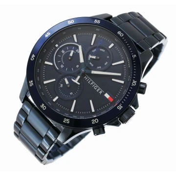 Oryginalny zegarek męski marki Tommy Hilfiger na stalowej, niebieskiej bransolecie. Fluorescencyjne, czarne wskazówki, białe indeksy i czarno-biały sekundnik na szarej, analogowej tarczy z chronografami - 24h, dzień tygodnia i miesiąca. Niebieska koperta zegarka o średnicy 46 mm.